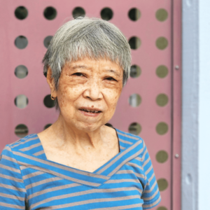 Senior woman in a blue and grey stripe top.
