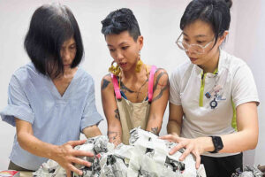 Agnes, Stacy and a Yishun Health staff member working on paper mache sculptures.
