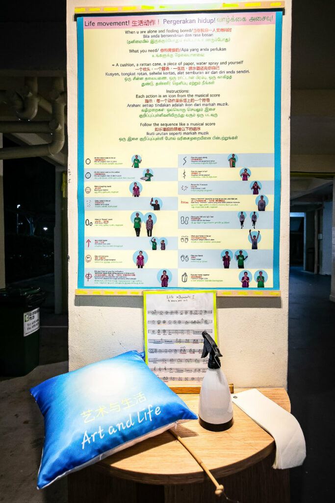 Instructional poster on Life m0vement gestures on a void deck pillar. Below the poster is a podium with a pillow, a cane and a water spray on it